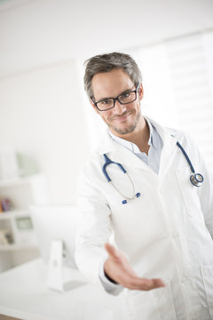 young doctor welcoming at his office