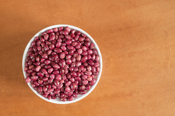 Red beans on a bowl, on wooden background