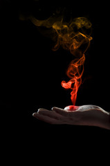 Hand holding a smoke shape colored on red an yellow