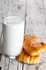 glass of milk and two fresh baked buns