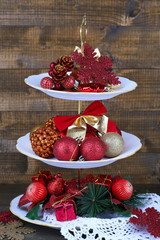 Christmas decorations on dessert stand, on wooden background