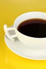 A cup of strong coffee on yellow background