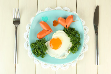 Sausages in form of hearts, scrambled eggs and parsley,