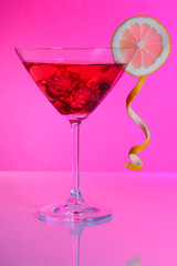 Red cocktail in martini glass  on pink background