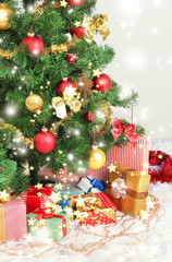 Decorated Christmas tree with gifts on grey wall background