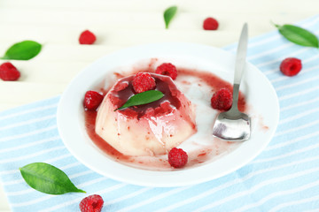 Panna Cotta with raspberry sauce, on wooden background