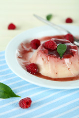 Panna Cotta with raspberry sauce, on wooden background