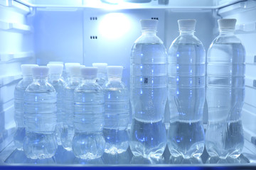 Bottles with water in refrigerator
