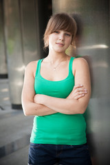 Young cute woman leaning against granite wall of building