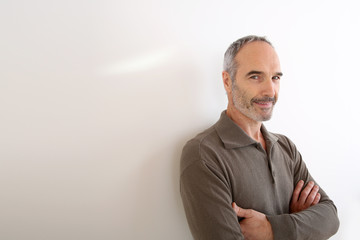 Portrait of 50-year-old man standing on white background
