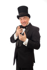 Elegant man in tuxedo and top hat a white background.