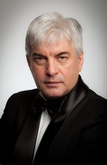 Elegant gray-haired man in a tuxedo.