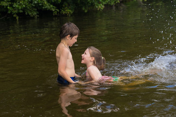 Fototapeta premium Little boy teaches his sister to swim
