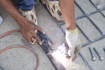 Worker welding steel bars.