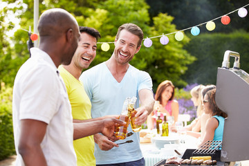Group Of Men Cooking On Barbeque At Home