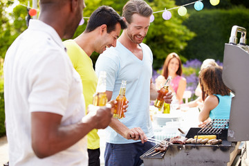 Group Of Men Cooking On Barbeque At Home