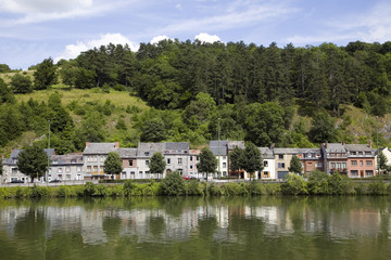 Fototapeta na wymiar Small houses reflecting in river Meuse, Dinant, Belgium