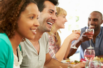 Group Of Friends Sitting Around Table Having Dinner Party