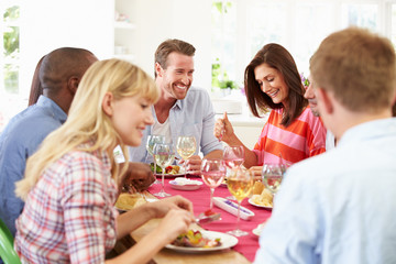 Group Of Friends Sitting Around Table Having Dinner Party