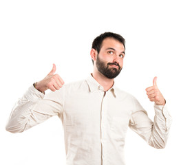 Young man with thumbs up over white background