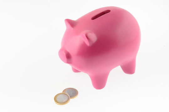 Maialino salvadanaio con monete isolato su sfondo bianco