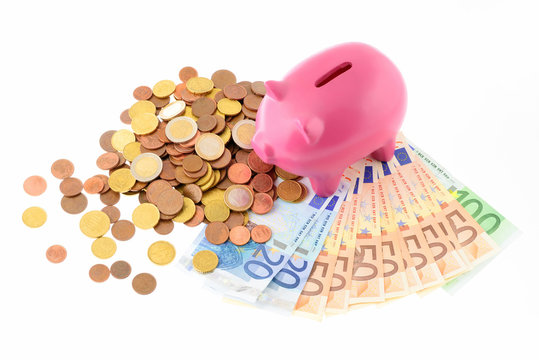 Maialino salvadanaio con monete isolato su sfondo bianco