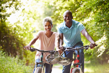 Mature African American Couple On Cycle Ride In Countryside - Powered by Adobe