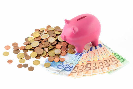 Maialino salvadanaio con soldi isolato su sfondo bianco