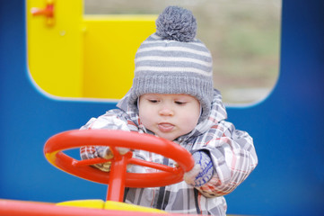 Fototapeta na wymiar baby driving car on playground