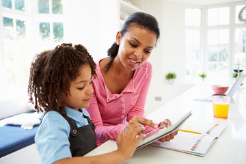 Mother And Child Using Digital Tablet For Homework