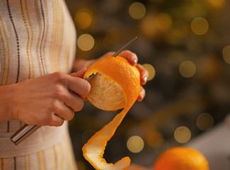 Closeup on young housewife removing orange peel