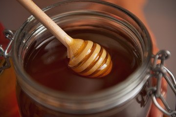 Closeup on honey dipper in honey jar