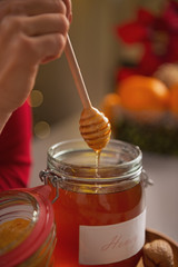 Closeup on honey flowing down from honey dipper in jar