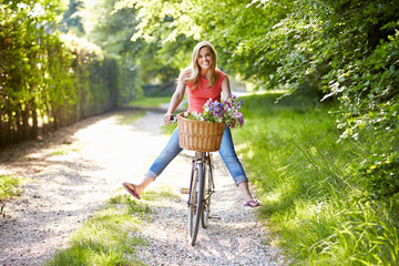 Woman On Cycle Ride In Countryside - obrazy, fototapety, plakaty