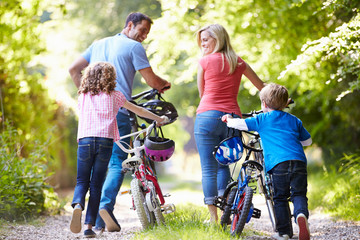 Family Pushing Bikes Along Country Track - obrazy, fototapety, plakaty