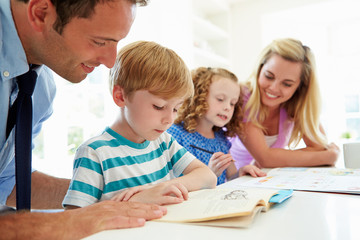 Fototapeta na wymiar Parents Helping Children With Homework In Kitchen