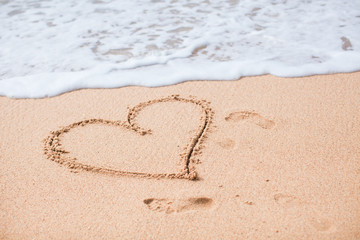 Fototapeta na wymiar Heart painted in the sand on a tropical beach