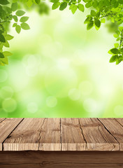 Obraz premium Fresh spring green bokeh background with wooden table