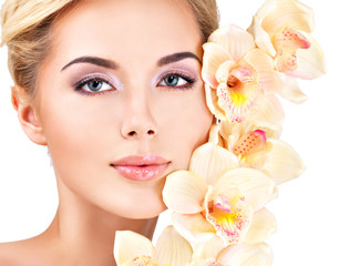 woman with healthy skin and flowers close to face