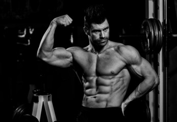 Fototapeta na wymiar black and white photograph of men showing his biceps in the gym