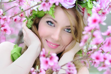 Beautiful girl in a flowered garden peach