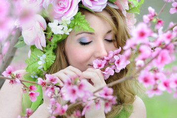 Naklejka premium Beautiful girl in a flowered garden peach