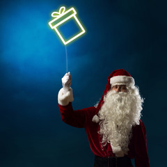 Santa holding a light symbol of the Christmas box