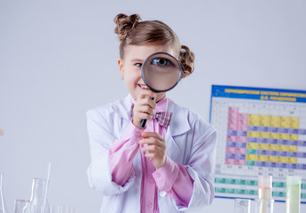 Adorable girl looking through magnifying glass