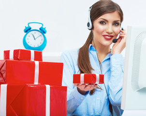 Smiling operator seat at table with red gift box. Happy busines