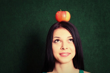 young female with an apple on the her head