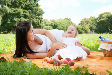 Young happy mother with daughter in the park