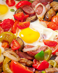 Fried eggs with fresh vegetables and sausage over white backgrou