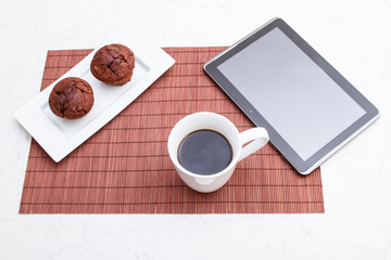 Chocolate chips Muffins with a cup of coffee and a tablet PC