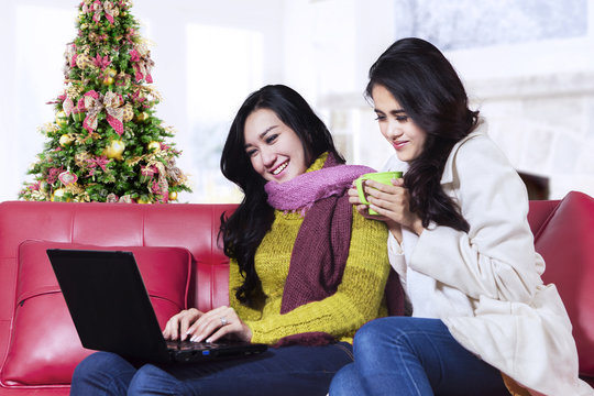 Two christmas woman using a laptop